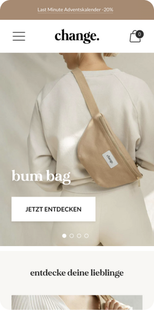 Frau trägt beigefarbene Bauchtasche quer auf cremefarbenem Pullover und Leggings vor Shop-Mobileansicht