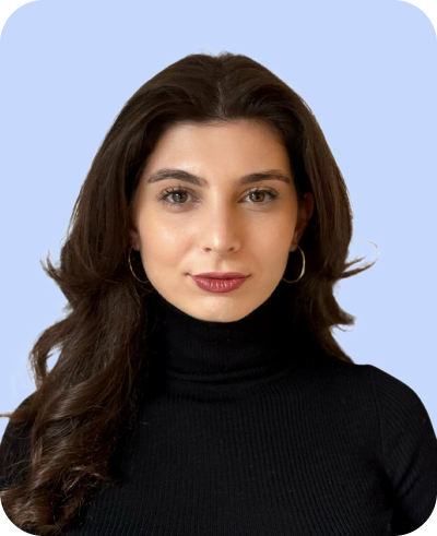 junge Frau mit dunkelbraunem welligem Haar schwarzem Rollkragenpullover dezenter Lippenstift vor hellem Hintergrund