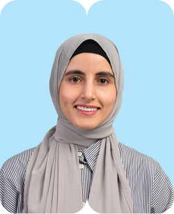 Lächelnde Frau mit grauem Hijab und gestreiftem Hemd vor pastellblauem Hintergrund